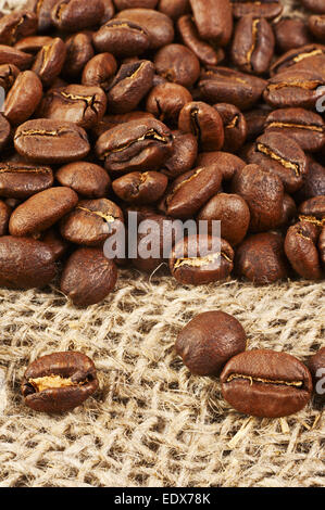 Geröstete Kaffeebohnen auf Sackleinen Hintergrund. Makroaufnahme mit Tilt-Effekt. Stockfoto