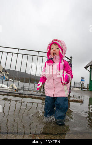 Lake Windermere, Cumbria, UK. 11. Januar 2015.  Lake Windermere Überschwemmungen über aber Touristen noch amüsieren. Niamh Hamill, Alter 2 aus Cheshire erfreut sich auf einen Tagesausflug mit ihren Eltern Credit: Gordon Shoosmith/Alamy Live News Stockfoto