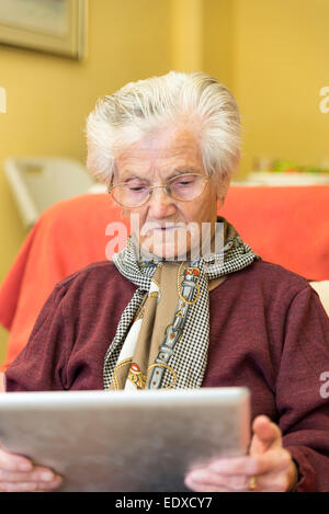 Oma lernen, eine Tablette für die geschäftliche Nutzung Stockfoto