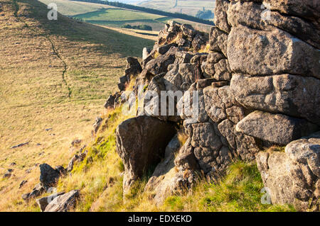 Gritstone Felsen auf dem Gipfel des Crook Hill im Peak District, Derbyshire. Einen angenehmen Abend Sommer Sonnenlicht. Stockfoto