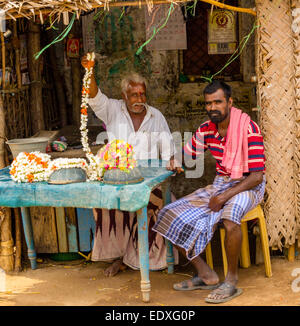 THANJAVOUR, Indien - Februar 13: Ein nicht identifiziertes indische Männer am Tisch sitzen und ein Mann zeigt eine Girlande aus Blumen.  Indien Stockfoto