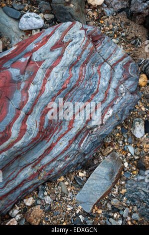 Interessante Geologie in den Felsen am Strand von Perranporth in Cornwall. Stripey blaue und rote Felsen. Stockfoto