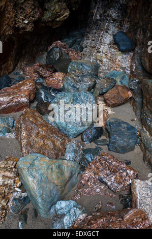 Interessante Geologie in den Felsen am Strand von Perranporth in Cornwall. Eine Mischung aus Felsen in einer feuchten Höhle. Stockfoto