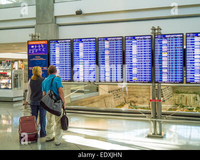 Paar auf der Suche bei Flug Informationstafel im Flughafen-terminal Stockfoto