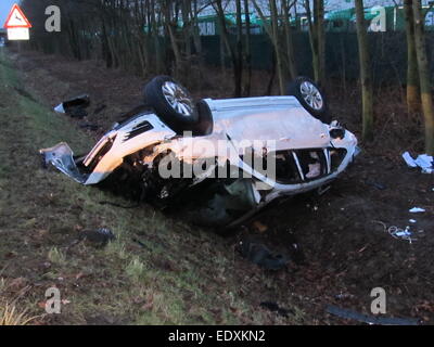 HANDOUT - ein Polizei-Handout-Bild zur 10. Januar 2015, zeigt eine beschädigte weißen VW Touareg liegenden seitlich am Hang entlang der Autobahn A2 bei Porta Westfalica, Deutschland. Berichten zufolge hat 20 Jahre alte defensiver Mittelfeldspieler Junior Malanda des deutschen Bundesligisten VfL Wolfsburg in dieser Autounfall getötet worden. Laut Polizei rutschte der Pkw bei überhöhter Geschwindigkeit, bevor Sie fliegen über eine Leitplanke und krachte in einen Baum und landet auf dem Dach. : Bildnachweis Polizei Bielefeld/Dpa obligatorisch Stockfoto