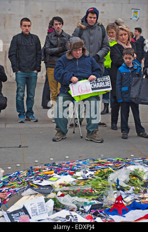 Trafalgar Square, London, UK. 11. Januar 2014. London-Rallye in Solidarität mit Frankreich nach den Terroranschlägen in Paris. Stifte, Bleistifte und Buntstifte sind in einer symbolischen Gruppe zusammen mit "Je Suis Charlie" Banner und Plakate platziert, während Leute schauen leider auf Stockfoto