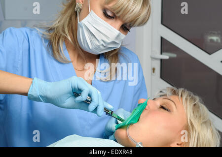 Zahnarzt mit Patienten, Installation von Kofferdam Stockfoto