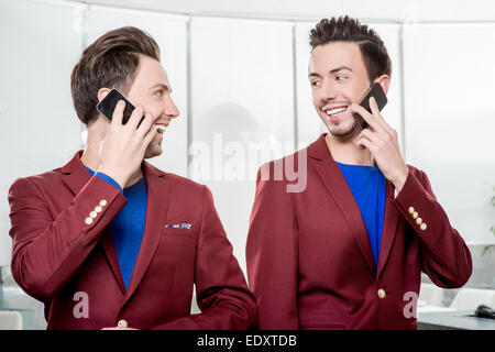 Geschäft Brüder Zwillinge mit Handys Stockfoto