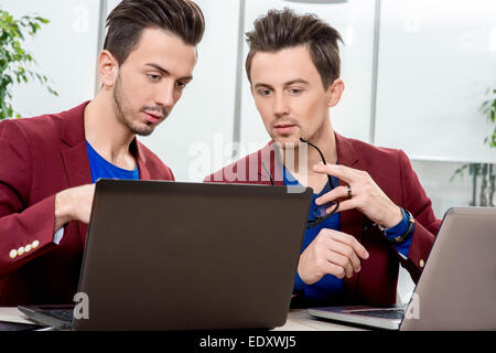 Zwei Brüder Zwillinge arbeiten im Büro Stockfoto