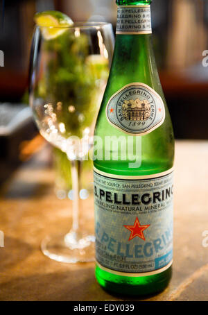 San Pellegrino Mineralwasser und Glas mit Limettenschnitz Stockfoto