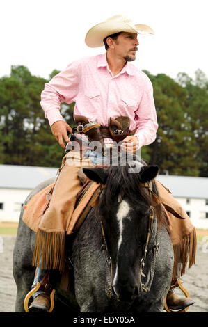 Mann reitet ein Pferd grau Geschütze im Holster an der Messe Scheune und Track in Pinehurst, North Carolina Stockfoto