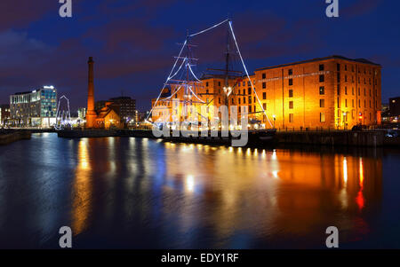 Merseyside Maritime Museum befindet sich am Albert Dock beleuchtet in der Nacht mit Segelschiff vor Anker in Canning Dock vor. Stockfoto