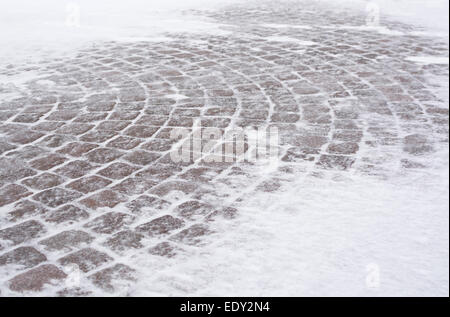 Straße Fliesen mit Schnee in windigem Schneewetter in Vällingby, Stockholm, Schweden im Januar. Stockfoto