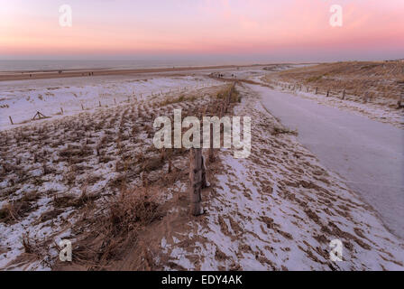 Katwijk Aan Zee, Südholland, Niederlande: Schnee am Strand und eine weiche rosa Sonnenuntergang über der Nordsee. Stockfoto