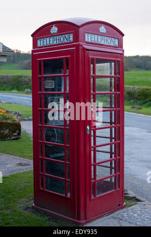 In der Nähe der traditionellen helle rote Telefonzelle oder Kiosk stehen country lane, eine Annehmlichkeit in Bolton Abbey Village, North Yorkshire, England, UK. Stockfoto