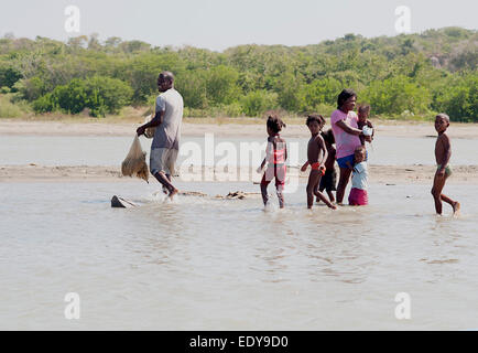 Familienszene Spaziergang durch Lagunen am Meer zurück in ihr Dorf nach einem Morgen Angeln in der Nähe von Cartagena, Kolumbien. Stockfoto