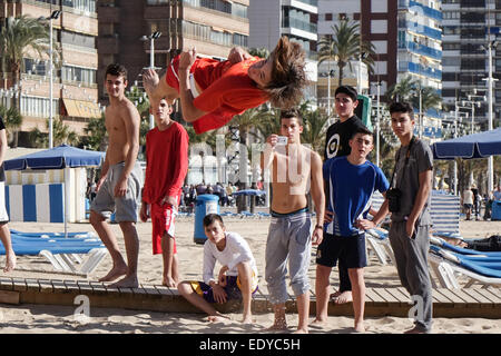 Tumbler Acrobat, akrobatische Jugend erscheinen zu gefrorenen Horizontal mit schnelle Verschlusszeit vor Freunden am Strand schweben Stockfoto