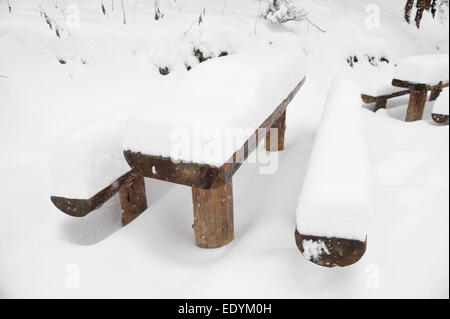 Hölzerne Picknick-Tisch mit Bänken nach starkem Schneefall Stockfoto