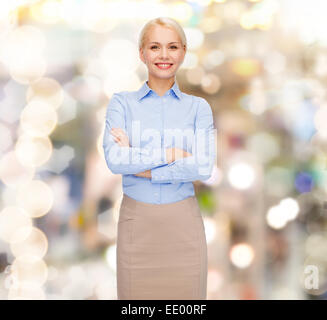 junge lächelnde Geschäftsfrau mit verschränkten Armen Stockfoto