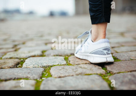 Bein der weiblichen Jogger laufen auf Asphalt. Schwerpunkt der Schuhe. Frau Füße auf Bürgersteig. Stockfoto