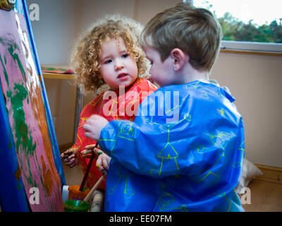 Kleinkind Jungen und Mädchen Alter 3 4 5 malen bei Abingdon Kindergarten in Abingdon, Oxfordshire, Vereinigtes Königreich Stockfoto