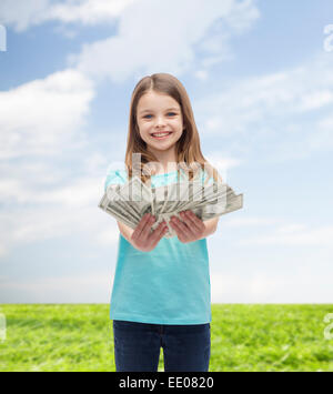 kleine Mädchen geben Dollar Bargeld lächelnd Stockfoto