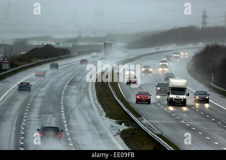 Pyle, UK. Montag, 12. Januar 2015 im Bild: Spray verursacht durch die M4-Autobahn in der Nähe von Pyle in Südwales Autos unterwegs.  Re: Leistungsstarke Jet-Streams bringen eine Reihe von Niederdruck Bereiche über den Atlantik verursacht stürmischen Wetterbedingungen in Teilen von der UK-Credit: D Legakis/Alamy Live News Stockfoto