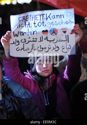 München, Deutschland. 12. Januar 2015. Ein Demonstrant hält ein Schild, das liest "Freiheit kann nicht abgeschossen werden tot" auf einer "München ist bunt" Demonstration in München, Deutschland, 12. Januar 2015. Die Demonstration wird gegen eine Rallye durch den Anti-Islam-Verein "Bagida" (Bayern gegen die Islamisierung des Abendlandes) gedreht. Foto: TOBIAS HASE/Dpa/Alamy Live News Stockfoto