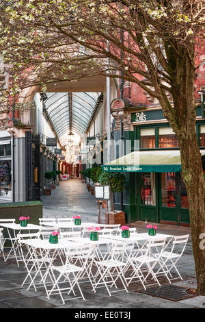 Tische und Stühle vor dem Eingang zum Wyndham Arcade. Stockfoto