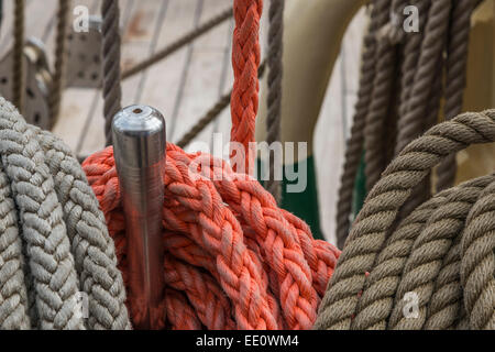 Seile und Belaying Pins auf dem Deck eines Schiffes Tall Ship Segeln. Stockfoto