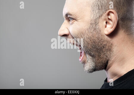 Porträt der böse Mann Sreaming isoliert auf grauem Hintergrund mit Exemplar Stockfoto