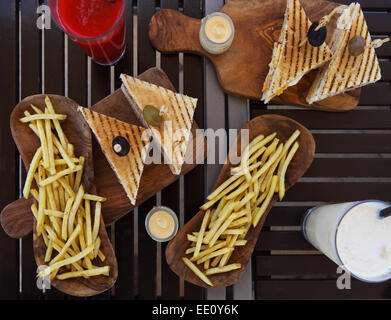 Chicken Club-Sandwiches und Pommes Frites mit Saft und schütteln auf dem Tisch Stockfoto