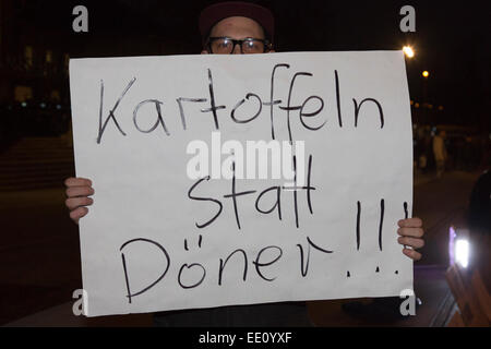 01.05.2015. Köln, Deutschland. Eine rechtsextreme Demonstrant hält einen Banner "Kartoffeln statt Döner" gefordert. Etwa zwei hundert rechtsextreme Demonstranten folgte einem Ruf zu demonstrieren gegen die Islamisierung Europas in Köln. KÖGIDA Demonstranten wurden von Tausenden von linksgerichteten Demonstranten weit unterlegen. Dies folgt der PEGIDA-Demonstrationen in Dresden, die eine große Zahl von Anhängern anzuziehen, zu halten. PEGIDA steht für "Patriotischen Europäische gegen die Islamisierung Europas". Als Protest blieb die Kölner Dom - in der Regel beleuchtet in der Nacht - dunkel aus Protest gegen th Stockfoto