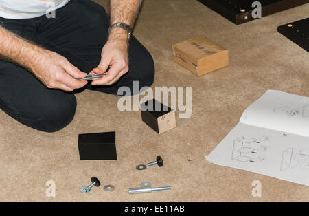 Dieser Mann ist flach verpackt Möbel Montage. Stockfoto