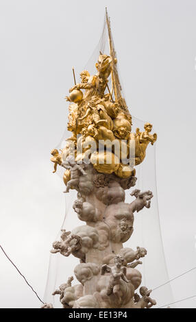 Die goldene Spitze des die Pestsäule in Wien. Fallen im Netz um Tauben zu entmutigen, ist es wie eine Wolke mit Engeln Stockfoto