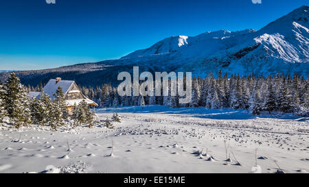 Kleine Hütte am Fuße der Berge im winter Stockfoto