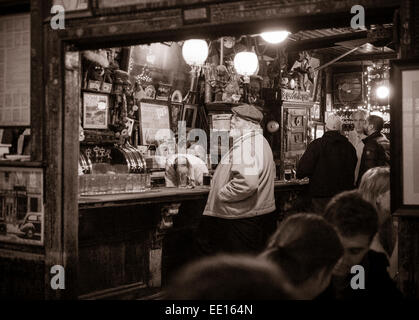 Die Bar im McSorley es Old Ale House: monochrom. Ein Mann steht an der Bar, während der Barkeeper etwas unterhalb der Leiste holt Stockfoto