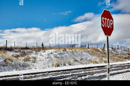 Stop-Schild auf der Straße mit Schnee bedeckt Straße Stockfoto