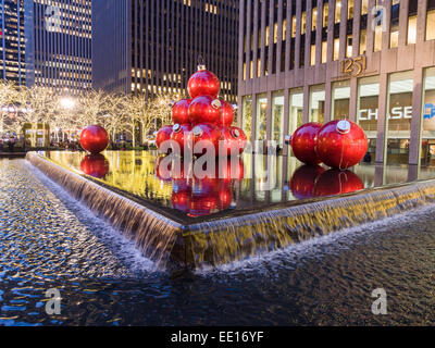Red Giant Weihnachtskugeln in ein Wasserbecken. Abends Blick auf riesige Weihnachtskugeln jährlich in das Reflexionsbecken platziert und Stockfoto