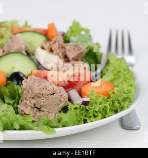 Thunfisch-Salat mit Tomaten, Karotten und Oliven mit Gabel auf einem Teller Stockfoto