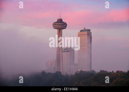 Nebel von Horseshoe Falls wirbeln vor Skylon Tower at Dawn, Niagara Falls, Niagara, Kanada Stockfoto