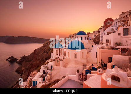 Griechische Kirche mit drei blauen Kuppeln bei Sonnenuntergang, Oia, Santorini (Thira), Kykladen, griechische Inseln, Griechenland, Europa Stockfoto