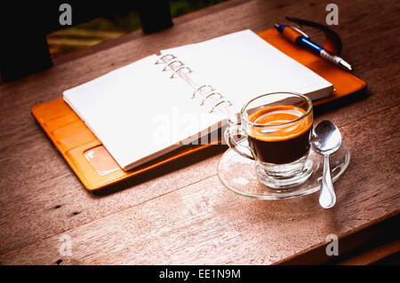 Notebook und Kaffee Tasse auf alten hölzernen Hintergrund, Business-Konzept Stockfoto
