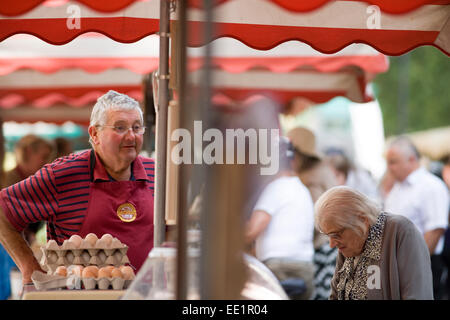 Ein Händler mit einem Kunden auf dem Bauernmarkt, Mais Straße, Bristol. Stockfoto