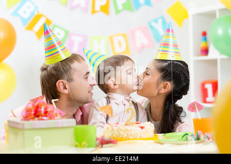 Eltern küssen ihren Sohn feiert Geburtstag Stockfoto