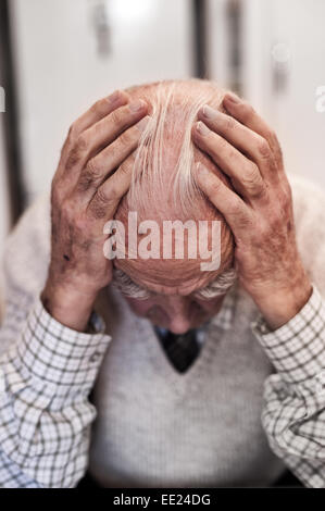 Holding zu den Kopf tief in obwohl sich Gedanken und Betrachtung der Trauer und Glück von früheren Zeiten-Erinnerungen eines Rentners Stockfoto