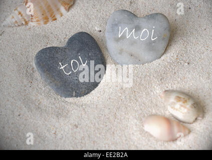 zwei herzförmige Stein mit Inschrift 'you' und 'me' auf Französisch (Toi et Moi) Stockfoto