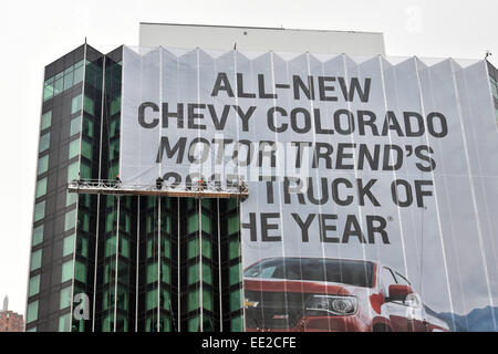 Detroit, Michigan, USA. 12. Januar 2015. Arbeitnehmer in Aufmachungen ein großes Banner Lesung "Brandneue CHEVY COLORADO MOTOR TRENDS der 2015 TRUCK OF THE YEAR" bei der North American International Auto Show (NAIAS) 2015 in Detroit, Michigan, USA, 12. Januar 2015. Die öffentlichen laufen vom 17. bis 25. Januar 2015. Foto: ULI DECK/Dpa/Alamy Live-Nachrichten Stockfoto