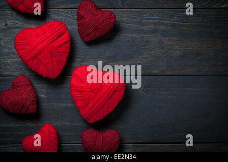Herz aus roter Wolle auf hölzernen Hintergrund zum Valentinstag. Kopieren Sie Raum. Ansicht von oben Stockfoto