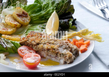 Kabeljaufilet paniert und gebacken mit Kartoffeln und Salat als Beilage Stockfoto